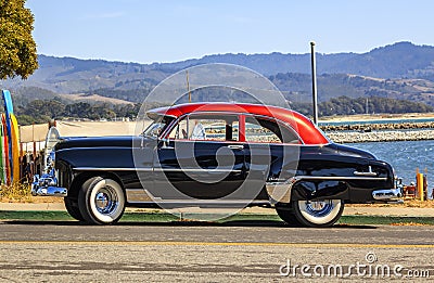 Classic 1950s Chevrolet Fleetline DeLuxe car in two-tone black and red outdoors in California Editorial Stock Photo