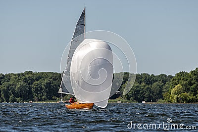 Classic sailing yacht with spinnaker on a lake in a regatta Stock Photo