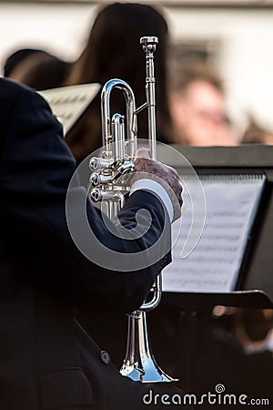 Classic silver trumpet in an orchestra. Sheet of musical notes in the background out of focus Stock Photo