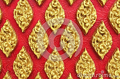 Classic Stone Carvings Thai Vintage Style Art of Golden Floral Seamless Pattern on Red Concrete Background Texture used as Beautif Stock Photo