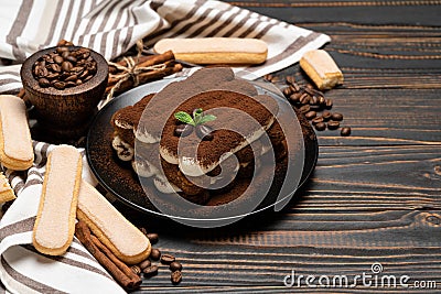 Classic tiramisu dessert on ceramic plate and savoiardi cookies on wooden background Stock Photo