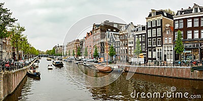 A classic water canal in Amsterdam, view from the bridge on the Dutch city buildings Editorial Stock Photo