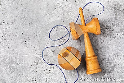Classic wooden Kendama toy with blue threads on a concrete background with copy space, top view Stock Photo