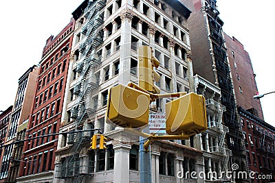 Classic yellow traffic lights at intersections in Manhattan against the background of buildings with fire escapes. Editorial Stock Photo