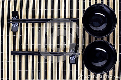 Classical asian chopsticks and black bowls Stock Photo