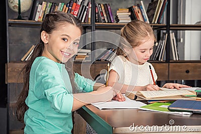 Classmates doing homework together in library Stock Photo