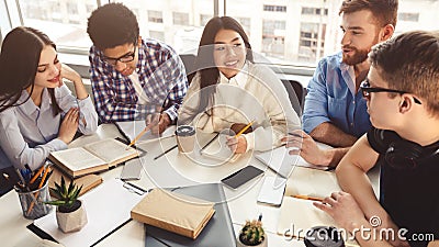 Classmates doing their project together, discussing material Stock Photo