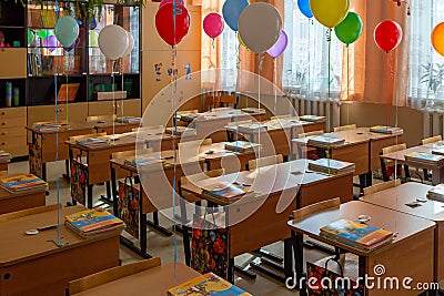 Classroom decorated for September 1st: colorful balloons over the desks, blur and grain effect. Editorial Stock Photo