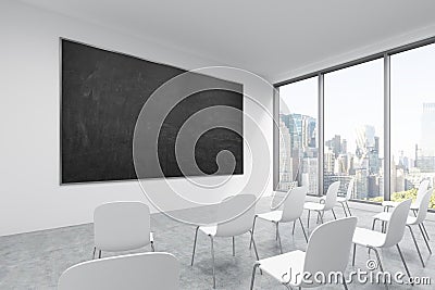 A classroom or presentation room in a modern university or fancy office. White chairs, a black chalkboard on the wall and panorami Stock Photo