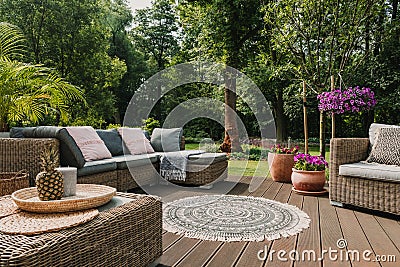 Furniture on wooden terrace in green beautiful garden Stock Photo