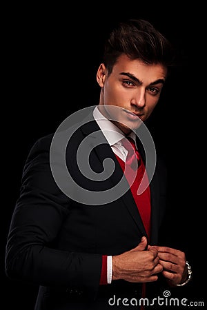 Classy young man in suit, fixing his jacke Stock Photo