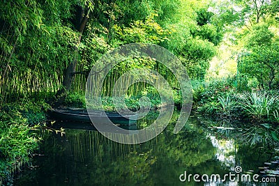 Claude Monet in autumn garden, boat in the lake among the bamboo groves Stock Photo