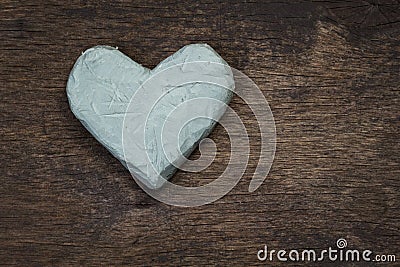 Clay heart on wooden surface Stock Photo