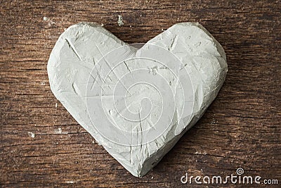 Clay heart on wooden surface Stock Photo