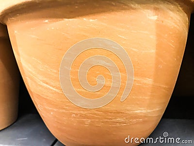Clay pot for growing plants, flowers. earth is poured into a pot of heterogeneous texture. texture with stains of orange color Stock Photo