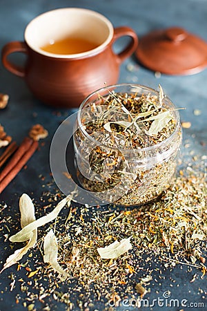 Clay pot with honey, cinnamon sticks, nuts and a herb collection Stock Photo