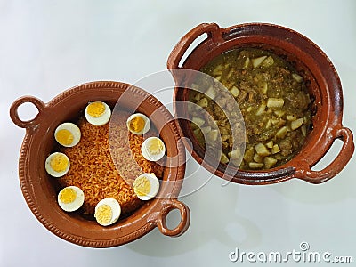 Clay pots filled with rice with boiled egg and pork rinds in green sauce Stock Photo