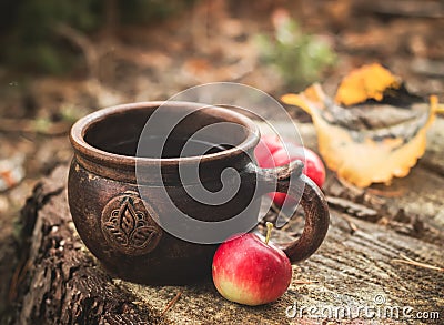 Clay Rural Cup with Hot Beverage and red apples on Wooden Stub. Stock Photo