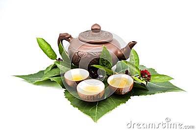 Clay teapot and cups with tea leaves Stock Photo