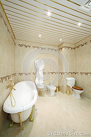 Clean bathroom with white bath, bathrobe, toilet and bidet Stock Photo