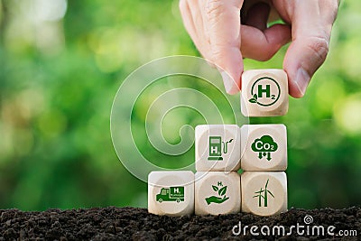 Clean hydrogen energy concept. Environment.Hand holding H2 green icon on wooden block.Eco-friendly industry. and alternative Stock Photo