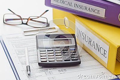 Clean insurance form, folders, pen, glasses and calculator Stock Photo