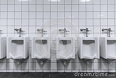 Clean male toilet row of urinals in a public restroom Stock Photo