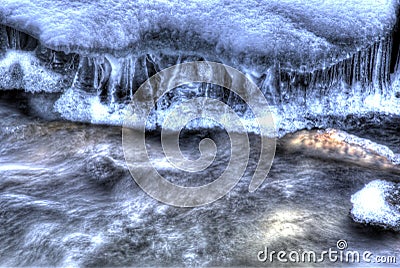 Clean mountain river stream in wintertime with icicles and small rocks closeup photo, multi exposure shot. full frame background Stock Photo