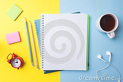 Clean notebook and pencil Cup of coffee and a clock with copy space on yellow blue table background for presentation, writer or Stock Photo