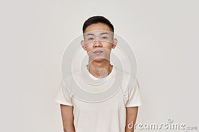 Clean skin. Portrait of young asian man with clean shaven face looking at camera isolated over white background. Beauty Stock Photo