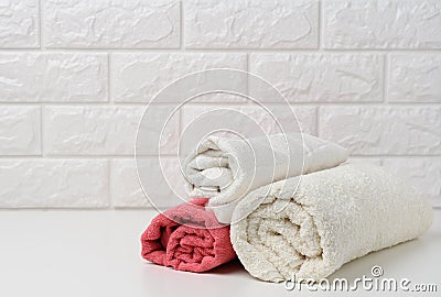 Clean white rolled terry towels on white shelf, bath interior Stock Photo