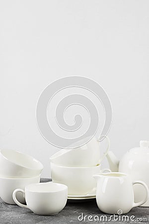 Clean white tableware teapot, cups, saucers on a gray backgrou Stock Photo