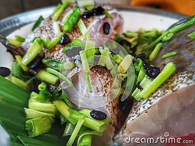 A cleaned grouper fish is prepared with black beans and some home ingredients is ready to steam. Stock Photo