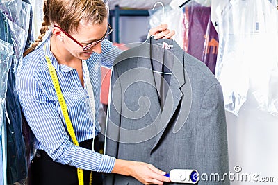 Cleaner in laundry shop checking clean clothes Stock Photo