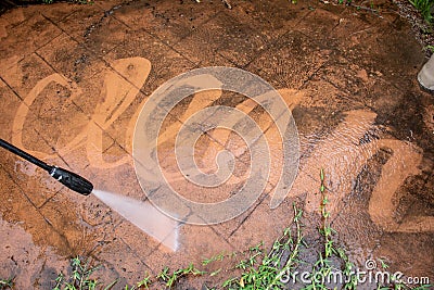 Cleaning backyard paving tiles with pressure washer Stock Photo