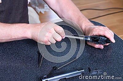 Cleaning the barrel of the pistol. Weapon care. Stock Photo