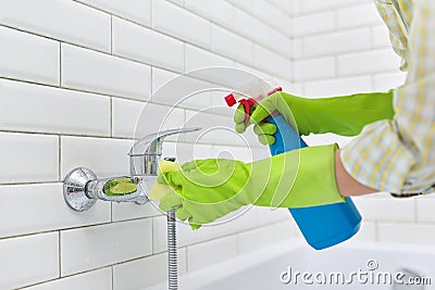 Cleaning the bathroom, woman washing tile wall and mixer with washcloth with detergent Stock Photo