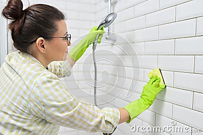 Cleaning the bathroom, woman washing tile wall with washcloth with detergent Stock Photo