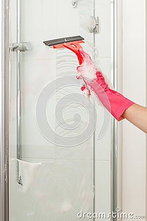 Cleaning a shower with a squeegee Stock Photo