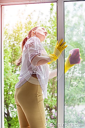 Cleaning concept. Young woman washing window Stock Photo