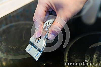 Cleaning dirty surface of black ceramic hob Stock Photo