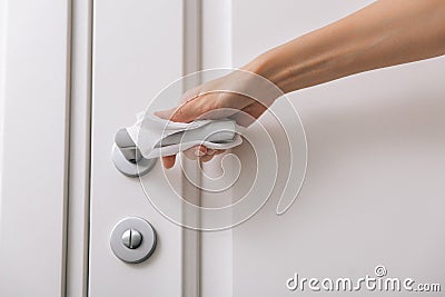 Cleaning door handles with an antiseptic wet wipe and gloves. Woman hand using towel for cleaning home room door link Stock Photo