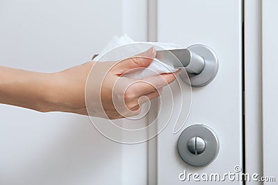 Cleaning door handles with an antiseptic wet wipe and gloves. Woman hand using towel for cleaning home room door link Stock Photo