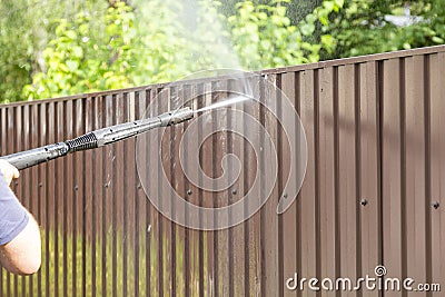 Cleaning fence with high pressure power washer, cleaning dirty wall Stock Photo