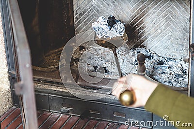 Cleaning fireplace. hand holding shovel with ash Stock Photo