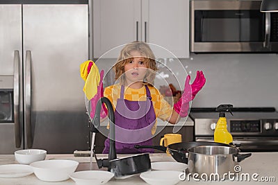 Cleaning at home. Child helping with household, wiping dishes in kitchen. Child helper housekeeping. Little boy sweeping Stock Photo