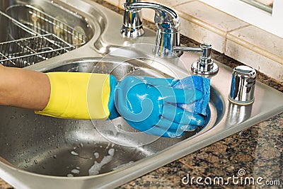 Cleaning inside of kitchen sink with soapy water and sponge Stock Photo