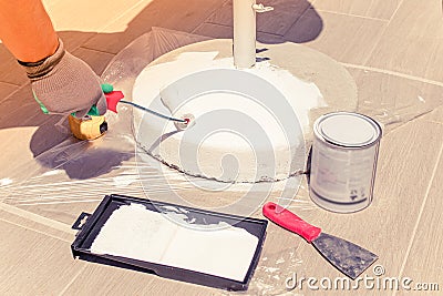 Cleaning and painting job of sun umbrella base. Concept of small scale repair and renovation jobs at home. Concept of preparing Stock Photo