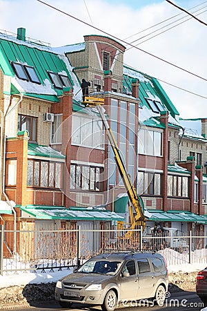 The cleaning service cleans the snow from the roof of the house. Editorial Stock Photo