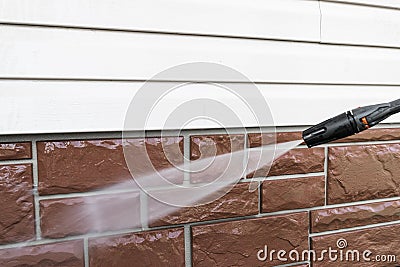 Cleaning service washing building facade with pressure water. Cleaning dirty wall with high pressure water jet. Power washing the Stock Photo